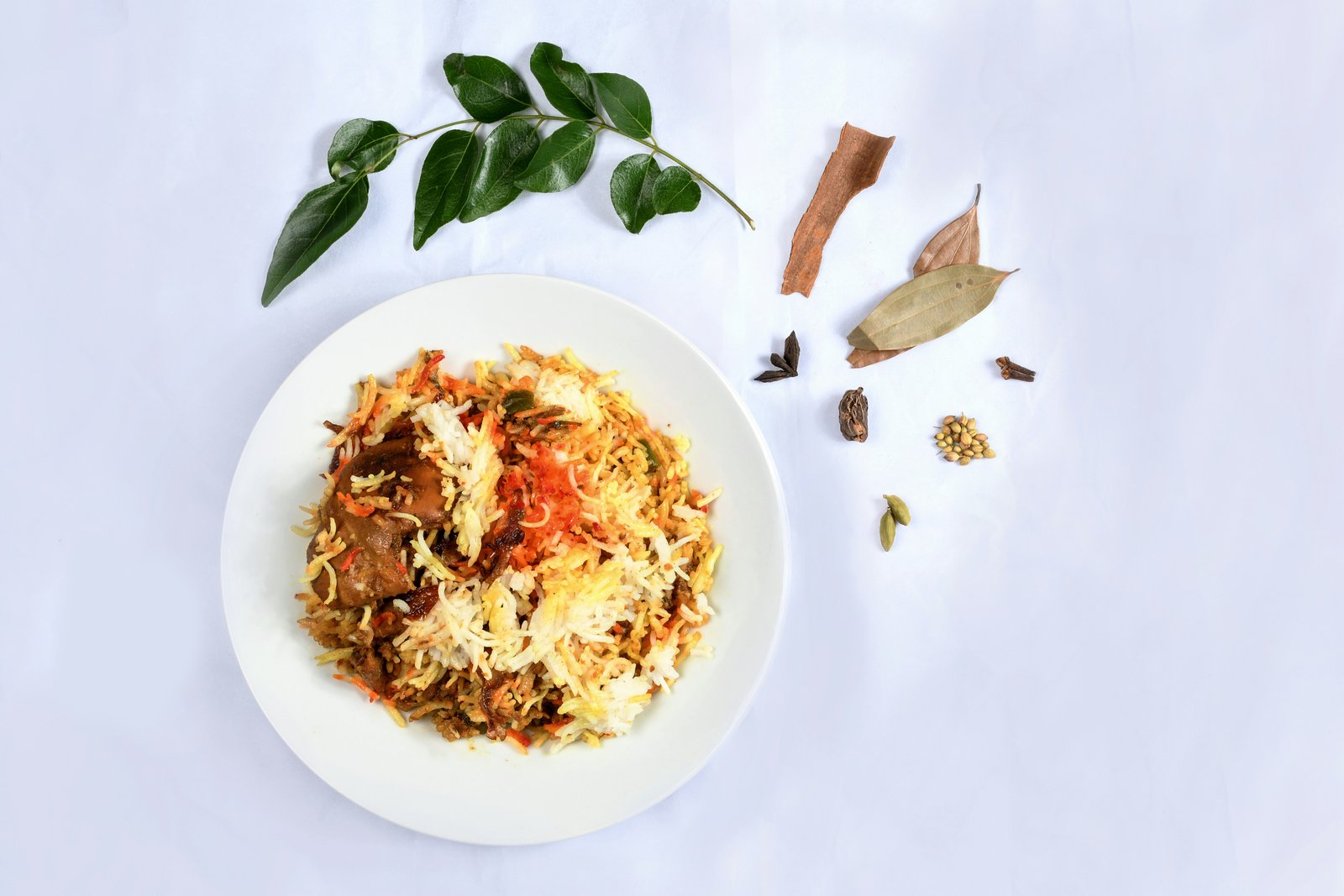 plated chicken biryani with raita and salad