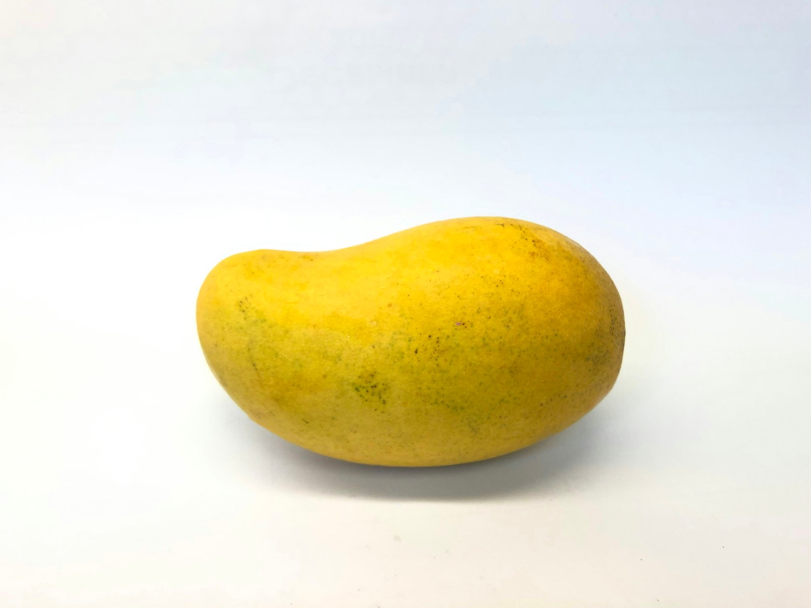 ripe yellow mangoes on wooden table