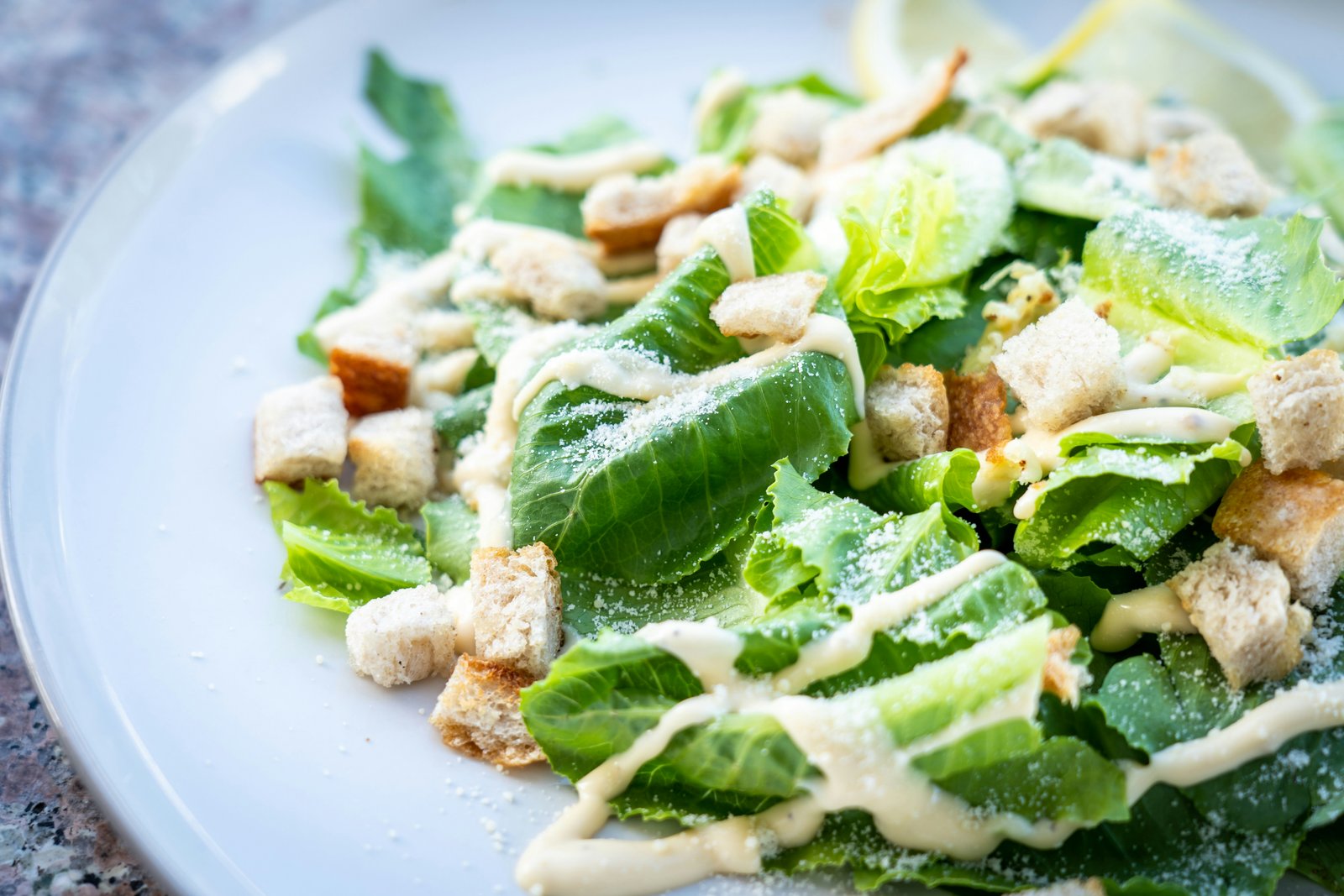 tossing caesar salad in large bowl